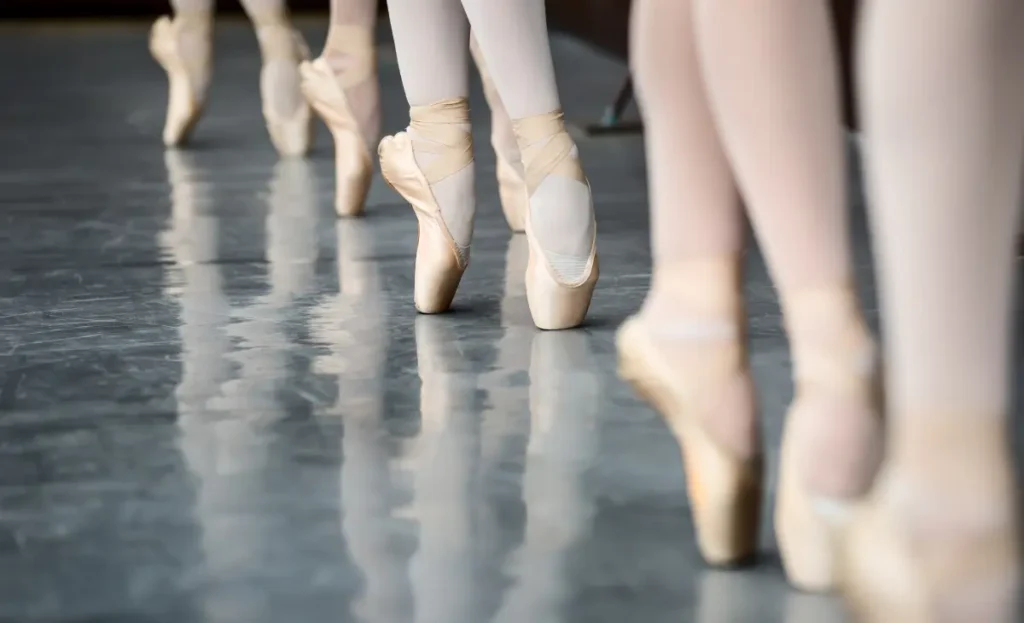 Close-up of dancers' feet standing in pointe shoes
