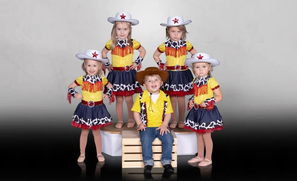 Tiny Tots dance classes represented with small group of little kids wearing cowboy and cowgirl costumes