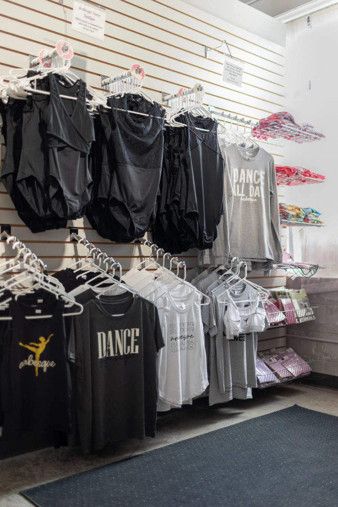 Arabesque dance studio boutique with wall of dance tops for sale